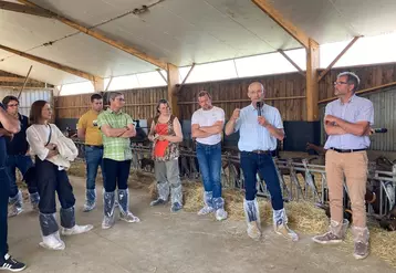 Visite chèvrerie, hommes et femmes dans bâtiment d'élevage caprin