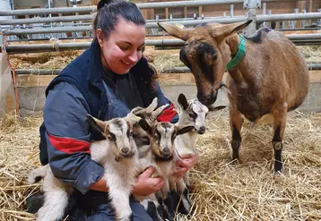 Eleveuse souriante, quatre chevrettes et une chèvre