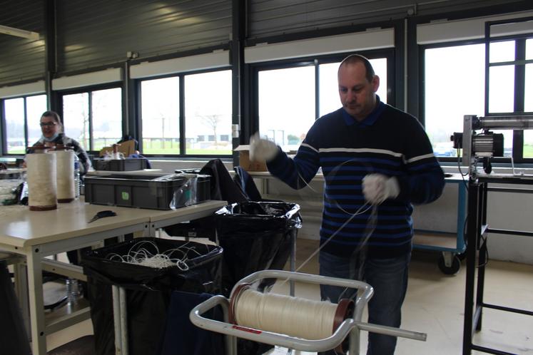 Les bobines de lin sont récupérées par les travailleurs pour le recyclage.