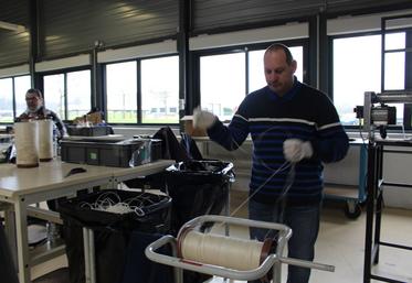 Les bobines de lin sont récupérées par les travailleurs pour le recyclage.