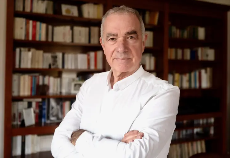 Daniel Sauvaitre, président d'Interfel, posant decant une bibliothèque remplie de livre. 