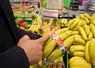 Une main de bananes enrubannée en bleu blanc rouge, dans un rayon de fruits et légumes de la grande distribution.