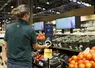 Dans un rayon fruits et légumes, une personne scanne un avocat