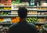 un homme devant un rayon de supermarché
