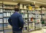 Un homme de dos, regardant des bidons de produits phytosanitaires, dans un local de stockage de produits phytopharmaceutiques. 