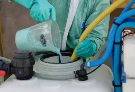 Versement de produit cuprique dans un pulvé.