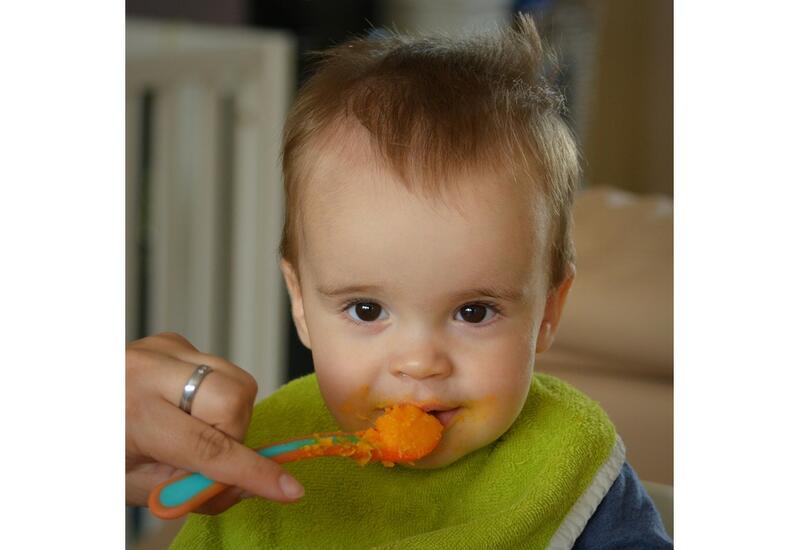 Enfant en bas âge mangeant des fruits et légumes en purée