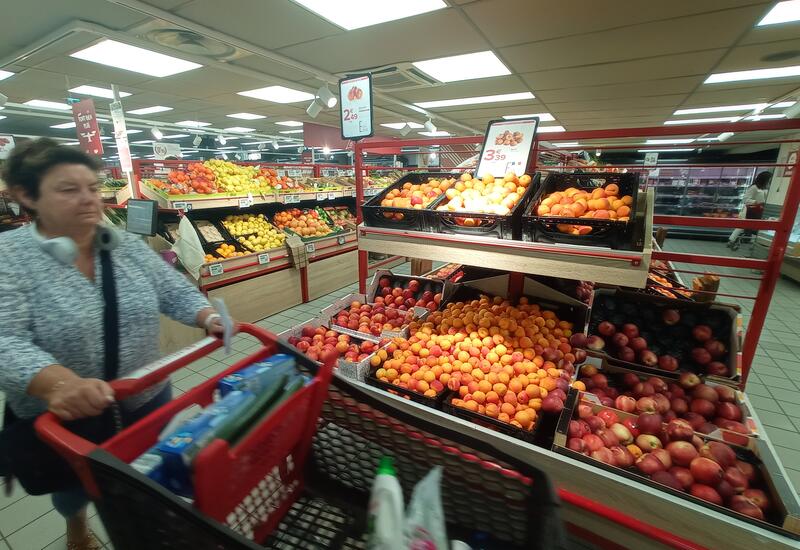 femme faisant ses courses et passant devant la gondole d'abricots et de pêches et nectarines en promotion. Carrefour Market Paris 12e jeudi 15 juin 2023