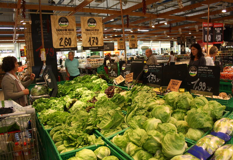 Consommateurs faisant leurs achats, dans un rayon de salades d'un supermarché en Italie.