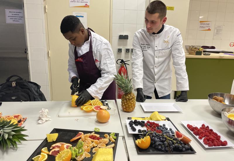 Wassim de Wasko'Fruits découpe un pomelo sous l'oeil attentif de Cristin Ambros, Meilleur apprenti primeur de France le 15 novembre 2023. 