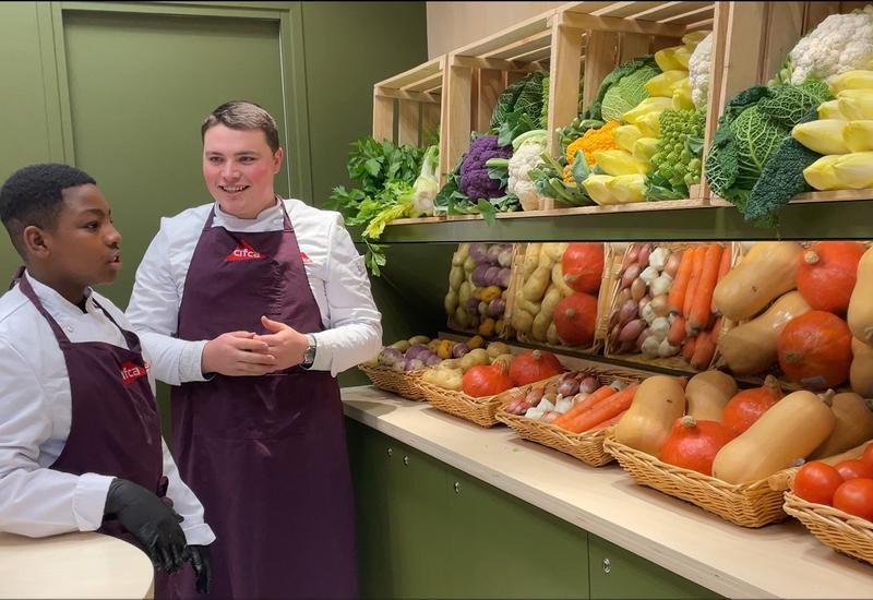 Wassim (Wasko'Fruits) avec un apprenti devant l'étal de légumes du Cifca à Paris. 