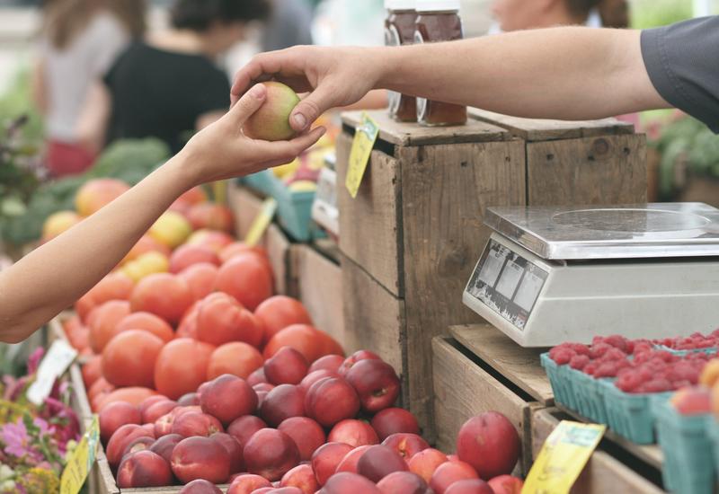 Achat d'une pomme au marché. 