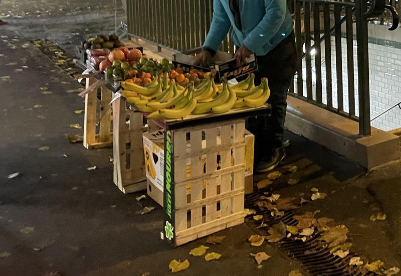 Etal fait de cagettes d'un vendeur à la sauvette de fruits et légumes à la sortie d'une bouche de métro à Paris.