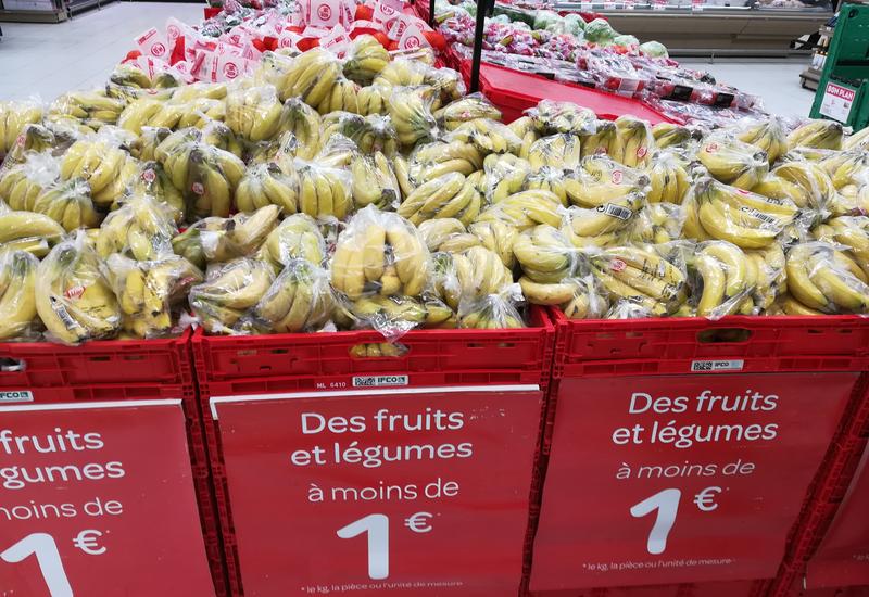 un rayon de bananes 1er prix dans leur sachet en plastique, avec l'indication "des fruits et des légumes à moins de 1€"