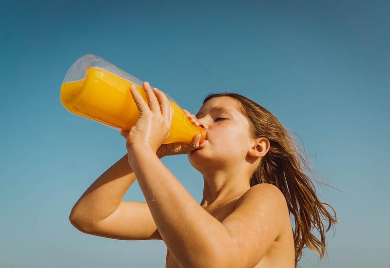 Enfant buvant une bouteille de jus de fruits
