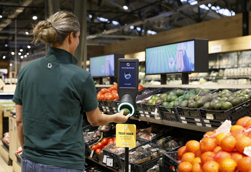 Dans un rayon fruits et légumes, une personne scanne un avocat