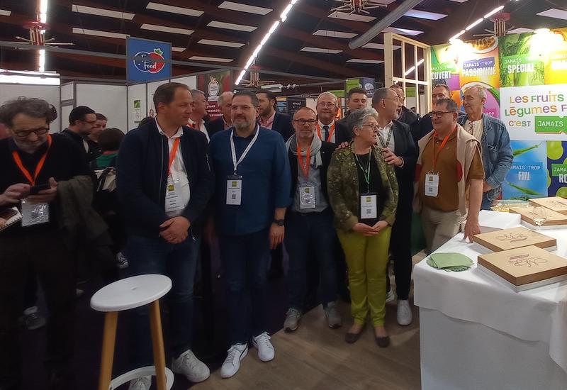 groupe de personnes qui posent sur un stand sur un salon