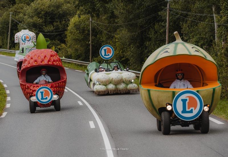 des véhicules en forme de fruits et légumes géants : melon, fraise, poireau et caché derrière la cerise