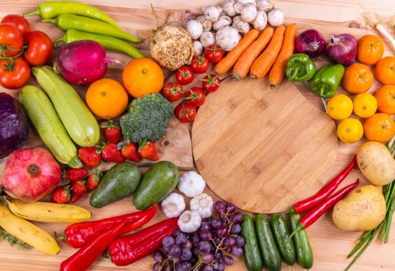 <em class="placeholder">Plusieurs fruits et légumes posés sur une table en bois, incluant des tomates, carottes, courgettes, poivrons, de l&#039;ail, des oranges, fraises, bananes, des grappes de ...</em>