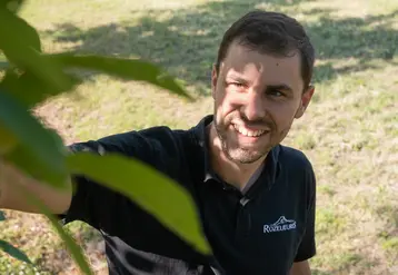 <em class="placeholder">Maxime Dupic, producteur de mirabelles en Lorraine, pose dans son verger, on voit seulement les feuilles des arbres. </em>