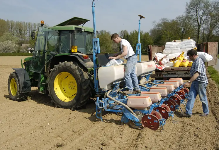 <em class="placeholder">un agriculteur et son apprenti travaillent sur un semoir dans un champ</em>