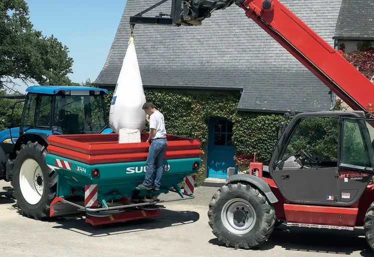 <em class="placeholder">Agriculteur déchargeant un sac d&#039;engrais dans son épandeur à engrais.</em>