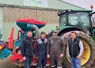 Groupe d'agriculteurs devant un tracteur et un semoir.