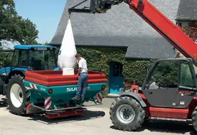 <em class="placeholder">Agriculteur déchargeant un sac d&#039;engrais dans son épandeur à engrais.</em>
