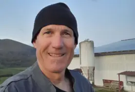 Charles Iralour, agriculteur à Ainhice-Mongelos (64), devant son bâtiment d'élevage couvert de panneaux photovoltaïques.