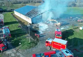 <em class="placeholder">Vue de drone de l&#039;incendie d&#039;un bâtiment agricole recouvert de panneaux photovoltaïques avec camion de pompiers</em>