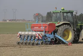 Agriculteur dans un tracteur procédant au semis de betteraves sucrières  