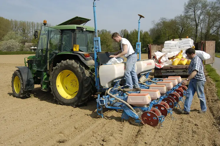 <em class="placeholder">un agriculteur et son apprenti travaillent sur un semoir dans un champ</em>
