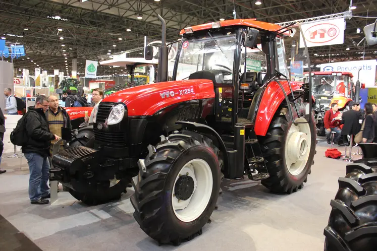 Agriculteurs devant un tracteur.