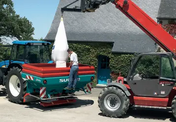 <em class="placeholder">Agriculteur déchargeant un sac d&#039;engrais dans son épandeur à engrais.</em>