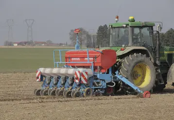 Agriculteur dans un tracteur procédant au semis de betteraves sucrières  
