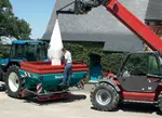<em class="placeholder">Agriculteur déchargeant un sac d&#039;engrais dans son épandeur à engrais.</em>