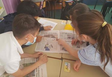 Des élèves d'une classe de CE2 à St Etienne dans la Loire feuillettent des journaux et magazines.
