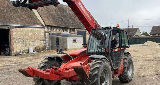 Un chargeur télescopique dans la cour d'une ferme eurélienne.