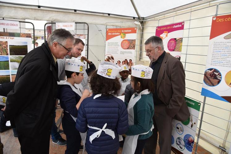 Le président de la chambre d’Agriculture échange avec des élèves d’une école primaire qui tentent de reconnaitre le blé à différents stades sur des cartes-photos.