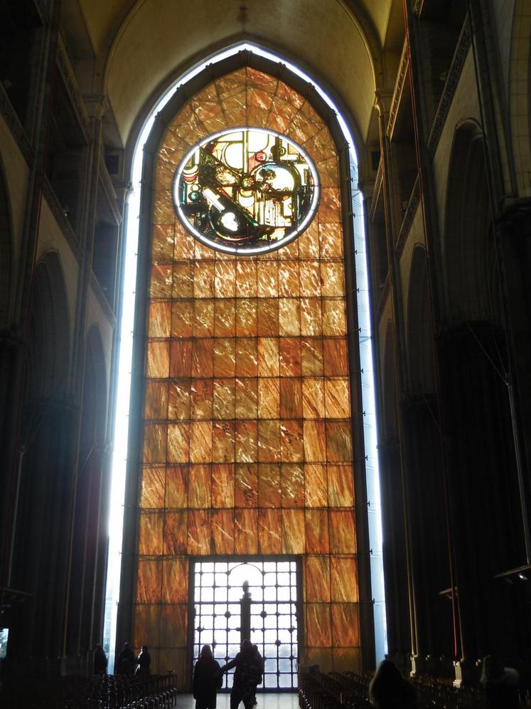La façade moderne, vue de l’intérieur. De jour, le marbre translucide laisse entrer une lumière ambrée dans la cathédrale. De nuit, c’est l’intérieur de la cathédrale qui semble irradier vers l’extérieur.
