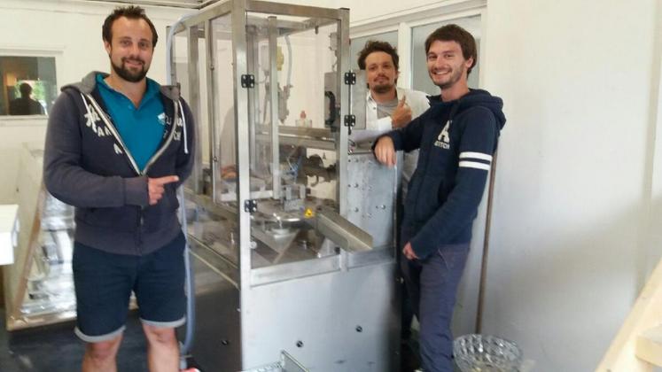 Les trois entrepreneurs dans leur nouveau laboratoire aux Alluets-le-Roi posent devant l’une des nouvelles machines : une empaqueteuse de 46000 euros.