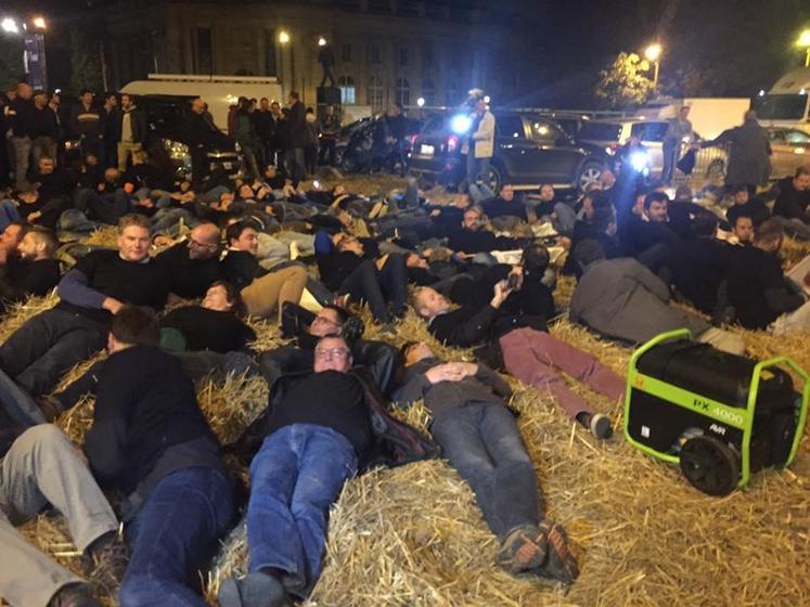 Des agriculteurs allongés en tee-shirt noir sur le sol pour signifier la mort prochaine de l’agriculture.