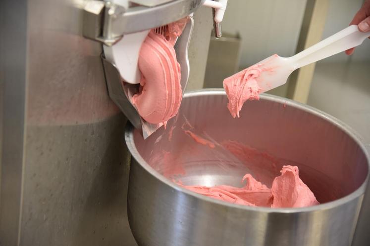 La glace à la framboise sort de la machine où elle a subi deux étapes nécessaires à sa préparation.