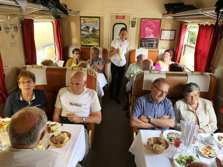 À bord du train, au son de l’accordéon et des explications des bénévoles, le groupe se délecte des produits du terroir.