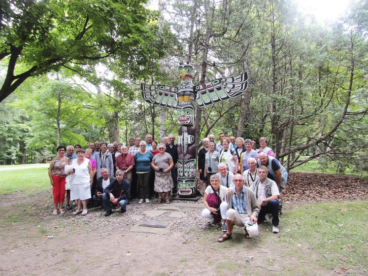 Le groupe pose devant une sculpture autochtone exposée au jardin de Rideau Hall, à Ottawa.