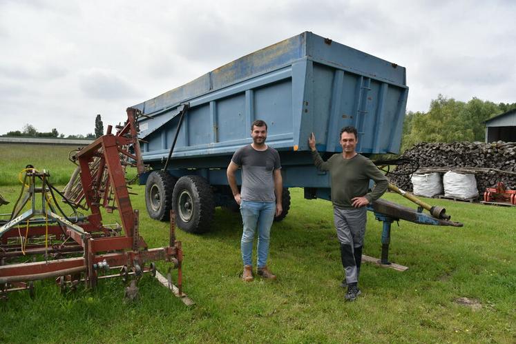 Jérôme Delouche et Bruno Chevallier, à Coudroy, siège social de la Cuma* du Canal, devant le plus ancien engin de la structure : une benne de 38 ans.