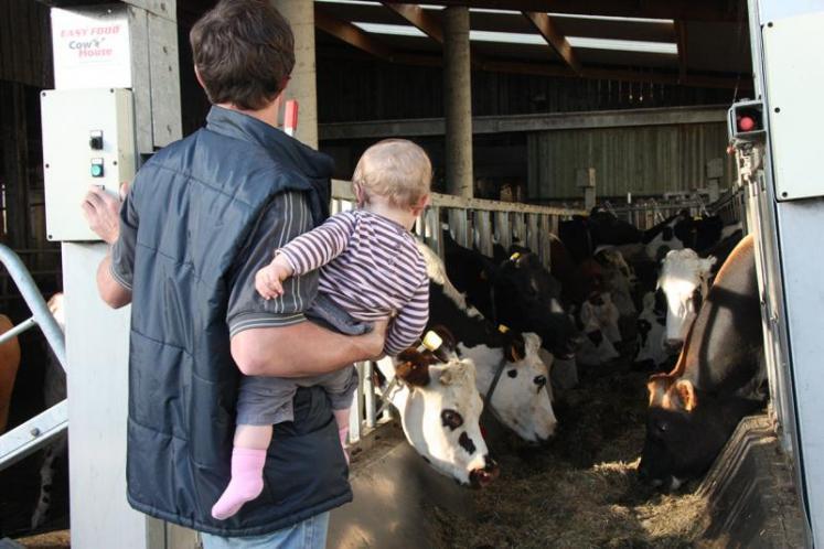 Un papa agriculteur et son bébé dans les bras.