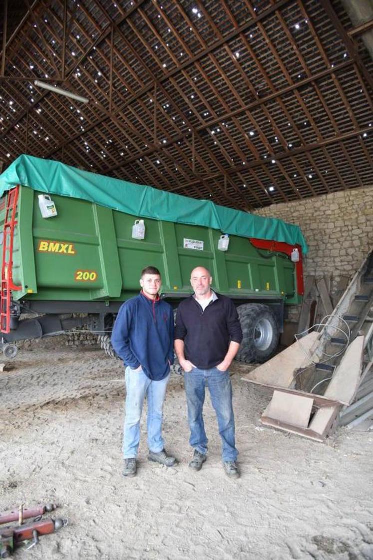 Benoit Durand (à d.) et son fils Germain, sous le bâtiment dont le toit a été criblé par la grêle.