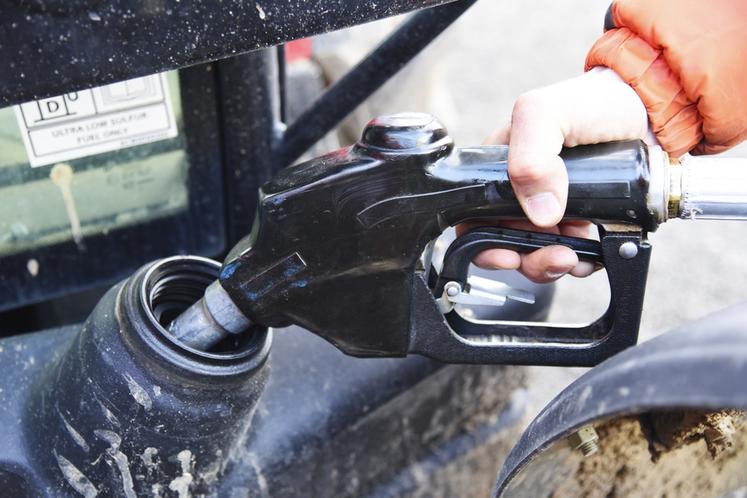 Un agriculteur met du carburant dans son véhicule.