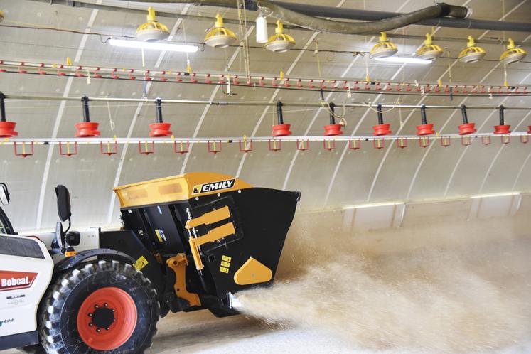 Démonstration de l'épandage de menue paille à l'aide d'un godet Multi'Spread Emily.